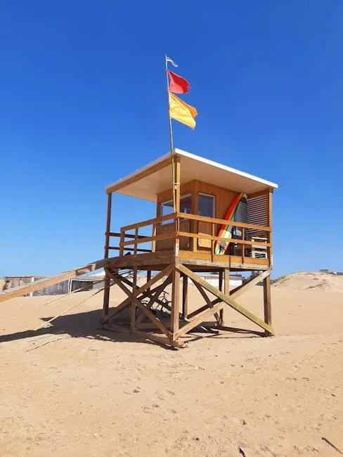 Wooden lifeguard hut with red and yellow flags on Lecce beach
