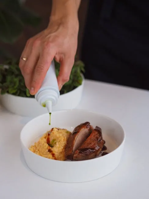 Hand drizzling oil over risotto and duck breast in a Lecce restaurant