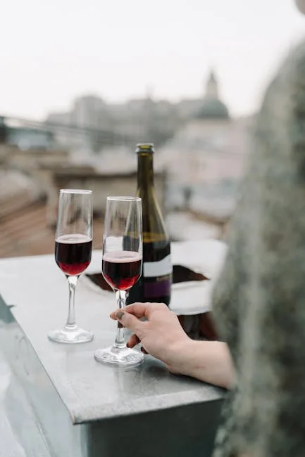 Hand holding a wine glass on Lecce rooftop with skyline view