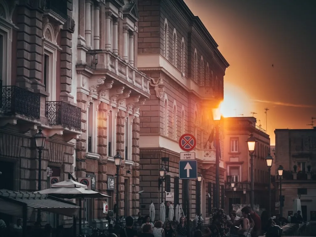 Sunset light along a busy Lecce street with ornate buildings