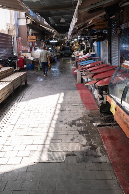 Empty covered market aisle with closed stalls and wet tiled floor in Lecce