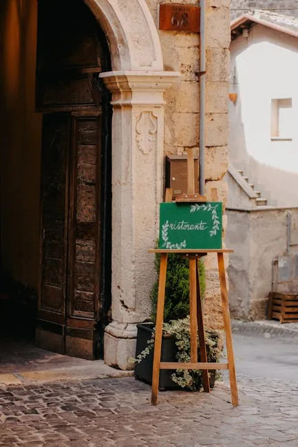 Green easel "ristorante" in front of an old door in a Lecce alley