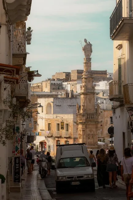 Narrow Lecce street framing the Sant'Oronzo column and cityscape