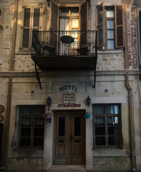 Stone facade of historic hotel in Lecce with balcony and shutters