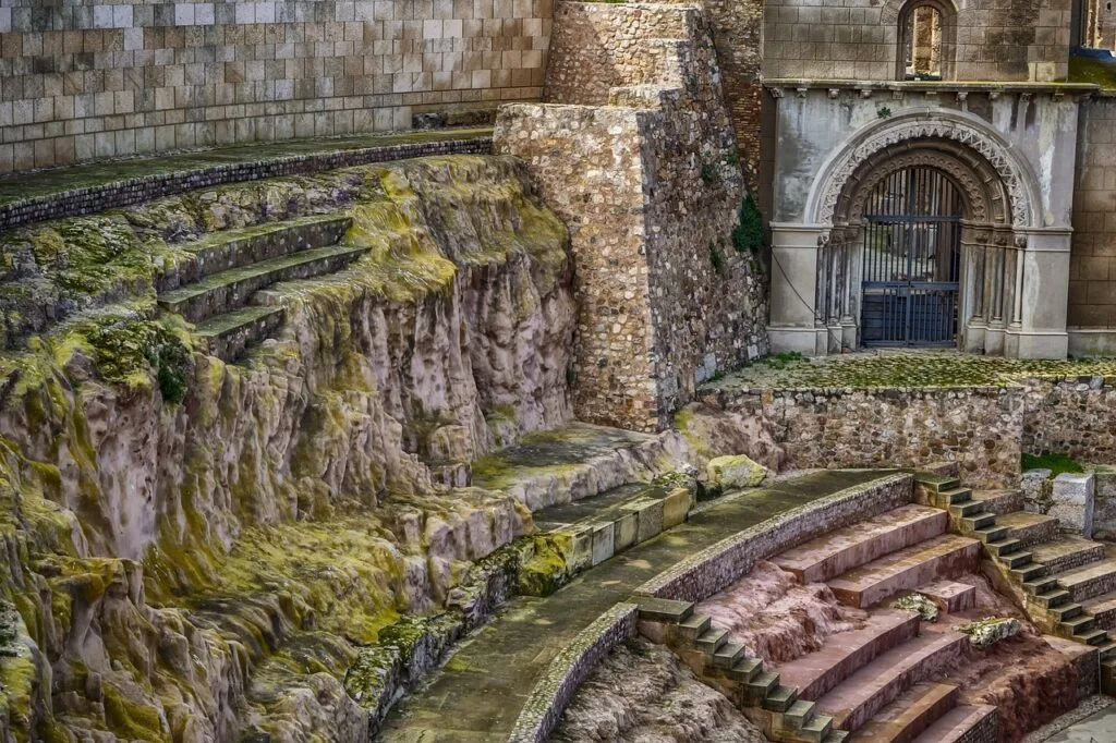 Mossy ancient amphitheater seating and arched stone wall near Lecce