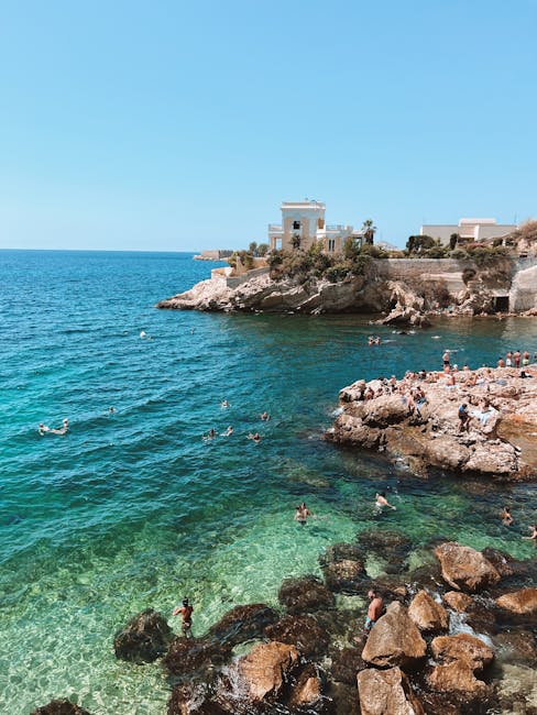 Felsklippen und Badegäste im türkisfarbenen Wasser nahe Lecce