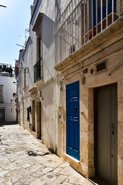 Narrow sunlit street in Lecce with a bright blue door