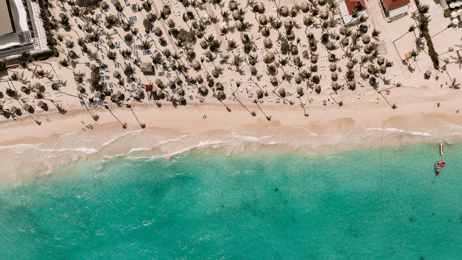 Luftaufnahme eines Strandes mit Palmen und Sonnenschirmen nahe Lecce